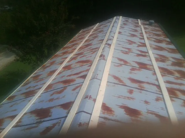 Rusted metal roof panels with new wood purlins before replacement — Storm Damage Roof Repair in Port Crane by Roofing Brothers