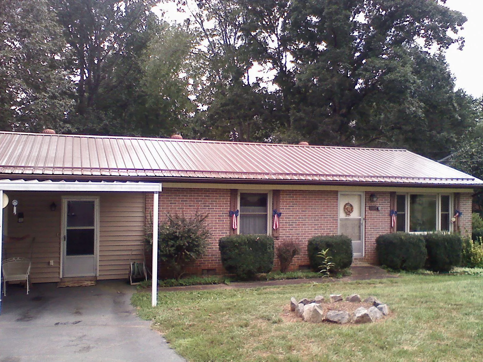 Bronze metal roof and carport on a brick ranch home — Roof Repair work by our crew in Port Crane